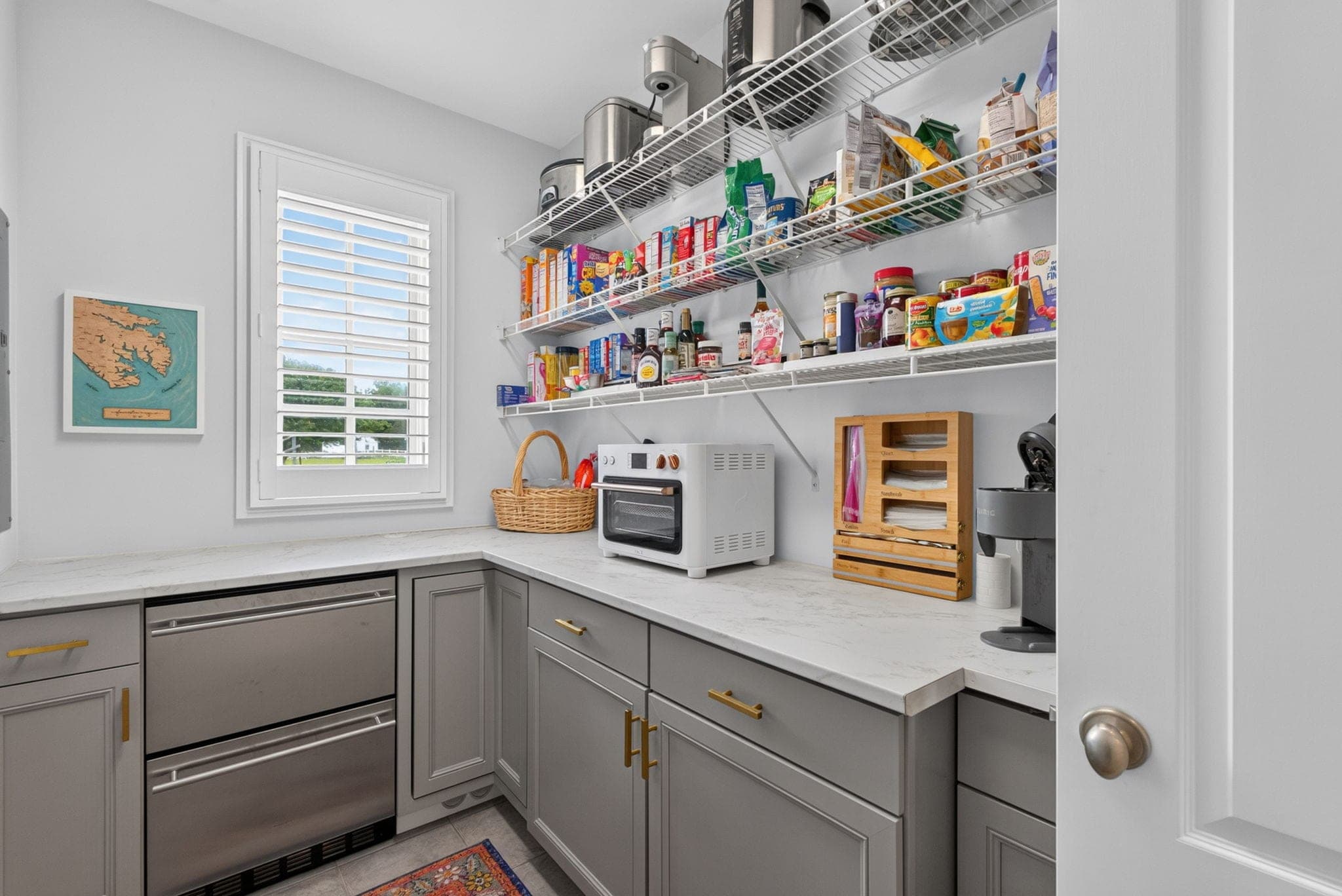 A true butler's pantry with its own counter, refrigeration drawers, and open shelving.