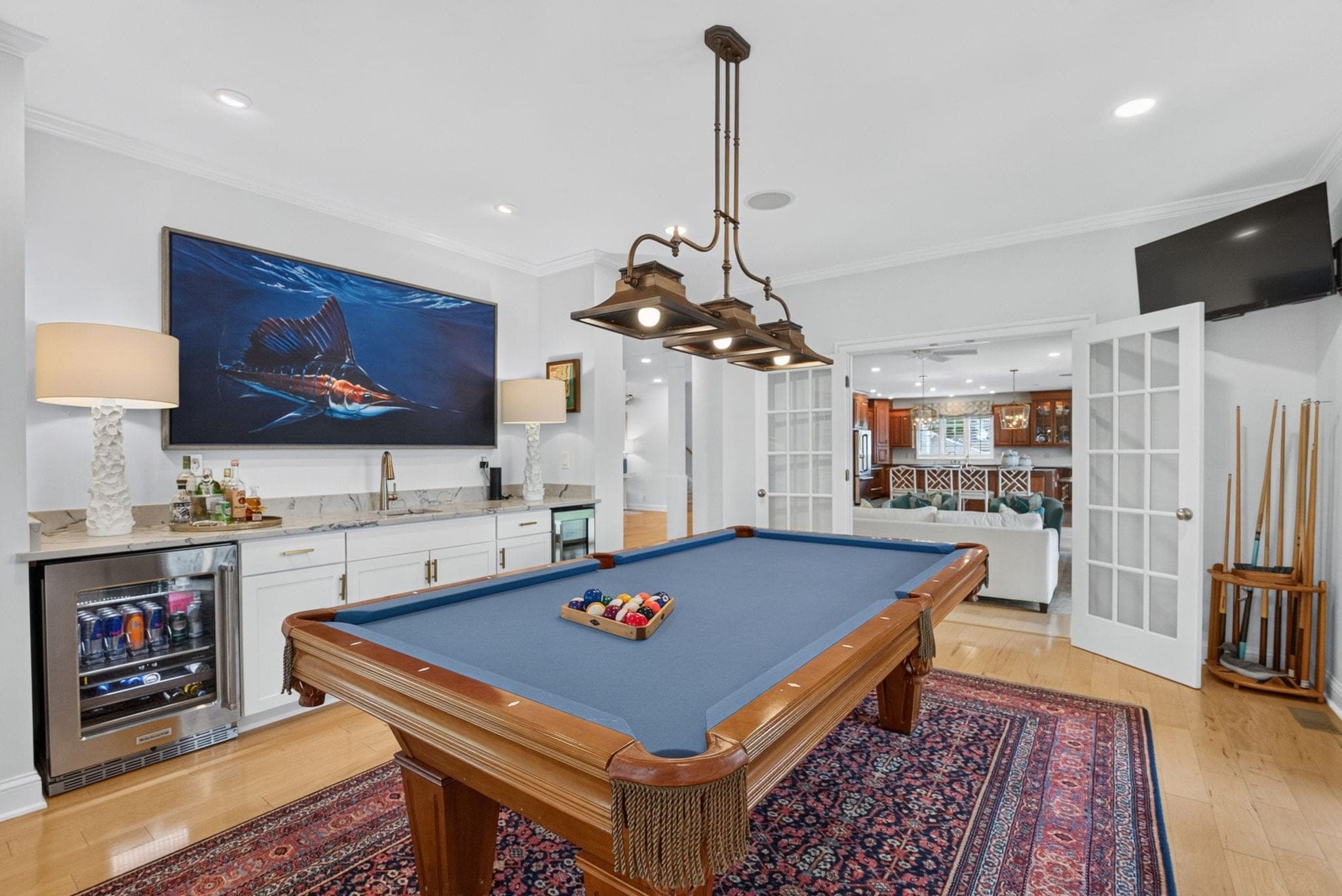 The billiards room with its own bar, beverage fridge, and French doors to the living room.